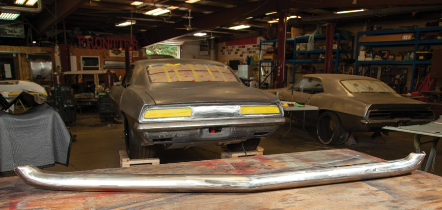 Rear side of the Camaro with the bumper laid on a work table