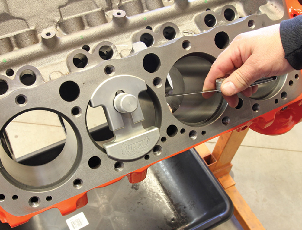 mechanic uses Summit Racing Piston Ring Squaring Tool to measure engine bore