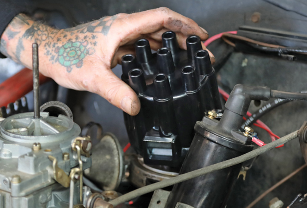 mechanic replaces distributor cap and rotor with new Duralast components