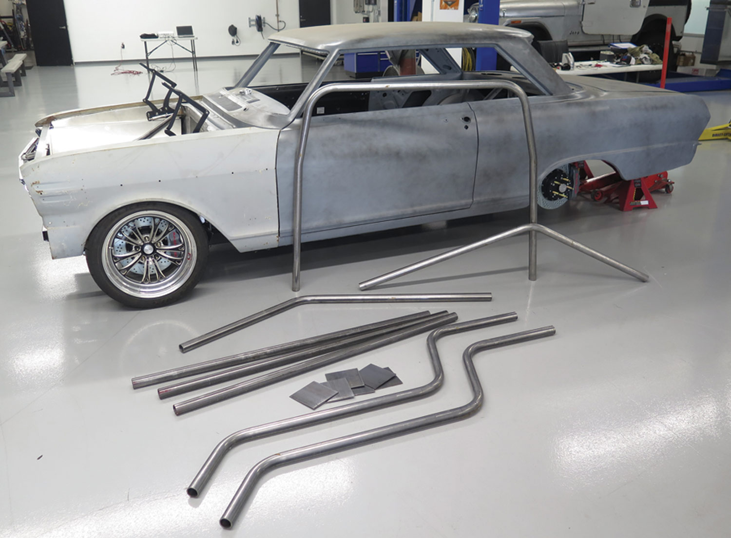 car with bent steel tubes near by, prepared for installation
