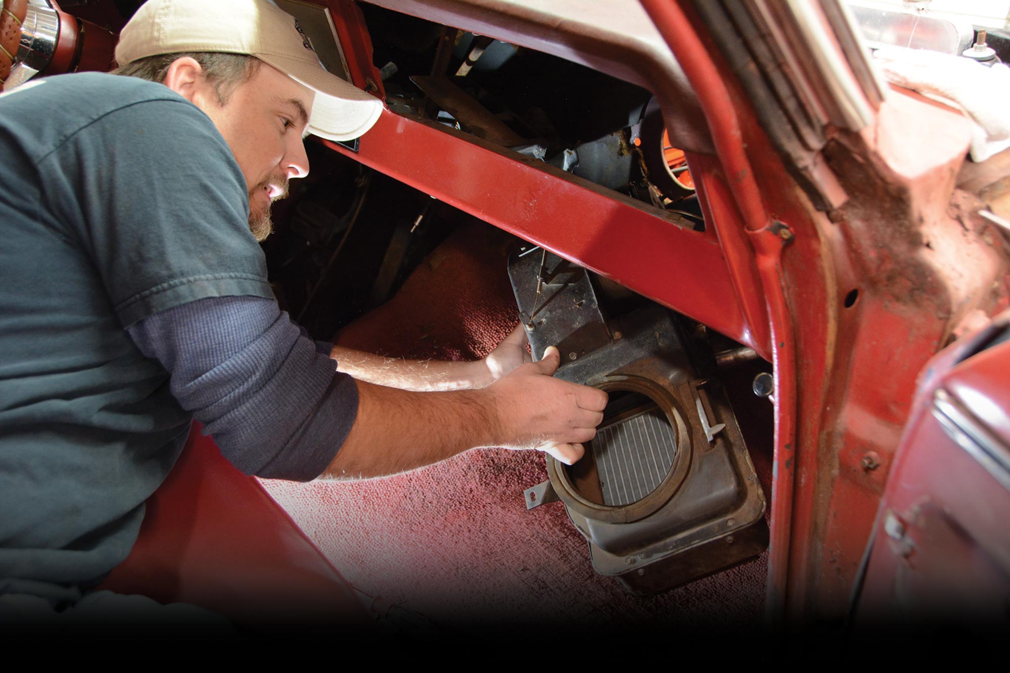 mechanic at work on the front, lower interior of a car