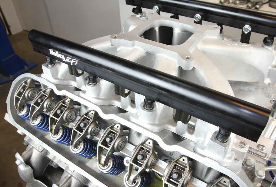 The stock LS3 fuel injectors are installed in the intake, held fast by the Holley fuel rails. 