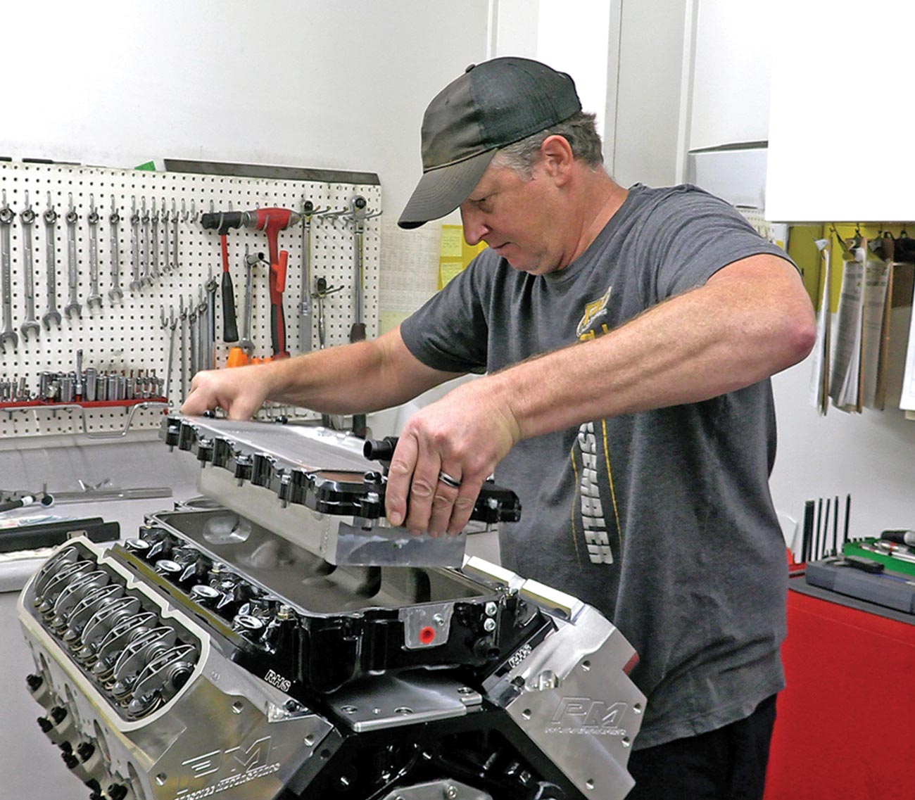 ngine assembler Larry Broeker lowers the intercooler into place