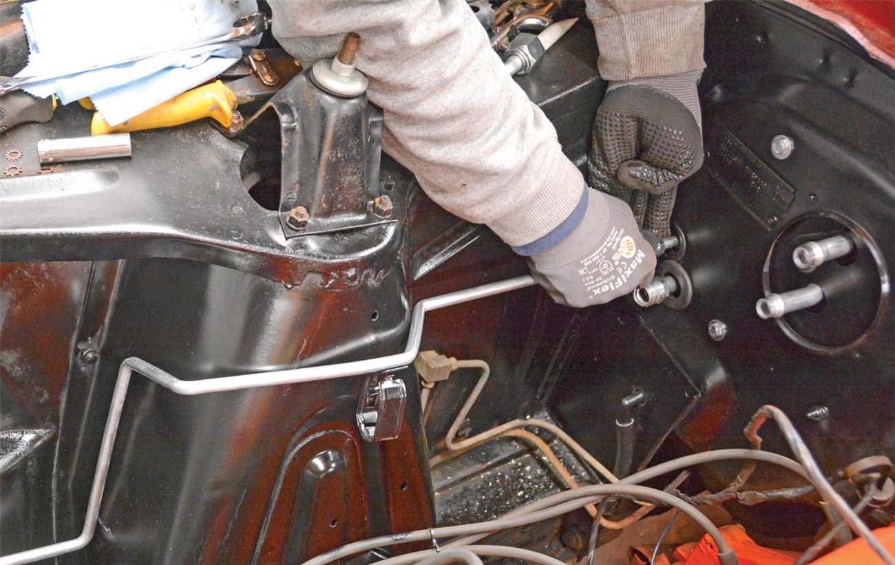 mechanic attaches the refrigerant lines in the engine bay area