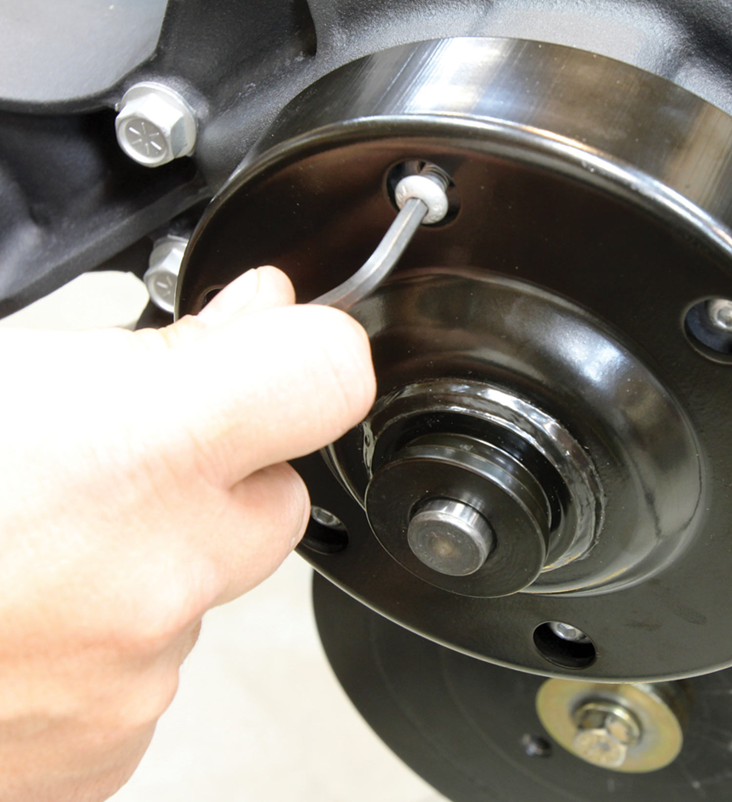 mechanic tightens a bolt to complete the installation of the LT1 cartridge-style water pump