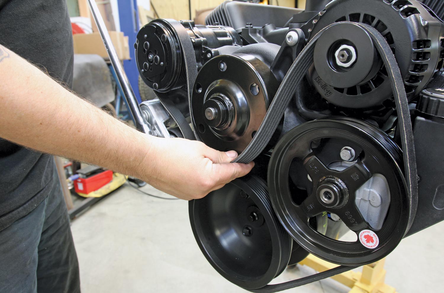 mechanic installs the serpentine belt