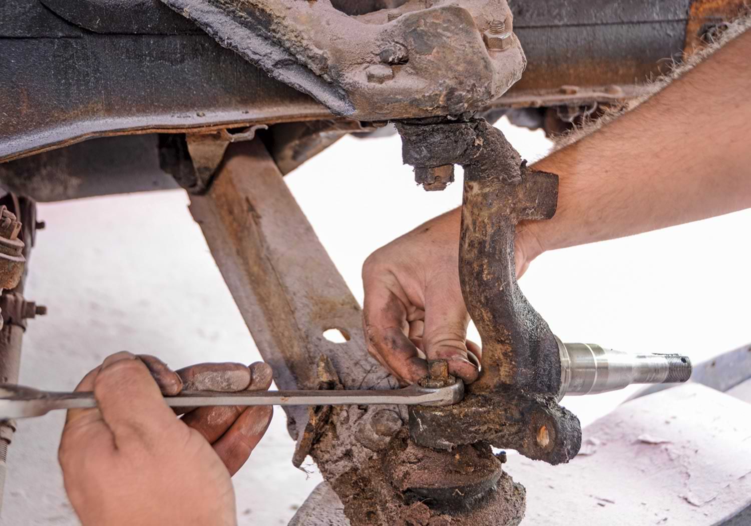 mechanic loosens a ball joint in preparation for a disk conversion