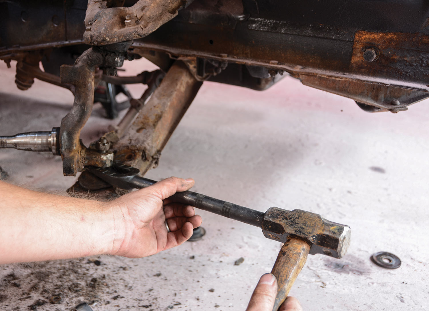 a mini sledgehammer is used to break the ball joint loose from the spindle