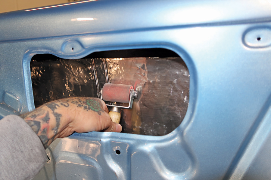 With the insulation slipped into the door, Scudellari used a roller to press it in place. Insulating the doors and quarter-panels reduces a significant amount of vibration and road noise.