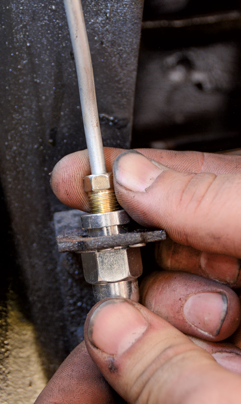 mechanic threads a line into a flex hose