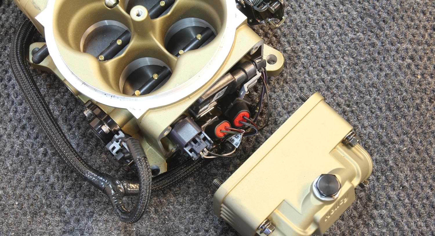 a Holley Terminator Stealth throttle body with the side bowl removed showing the hidden fuel injectors, MAP sensor, and fuel pressure sensor