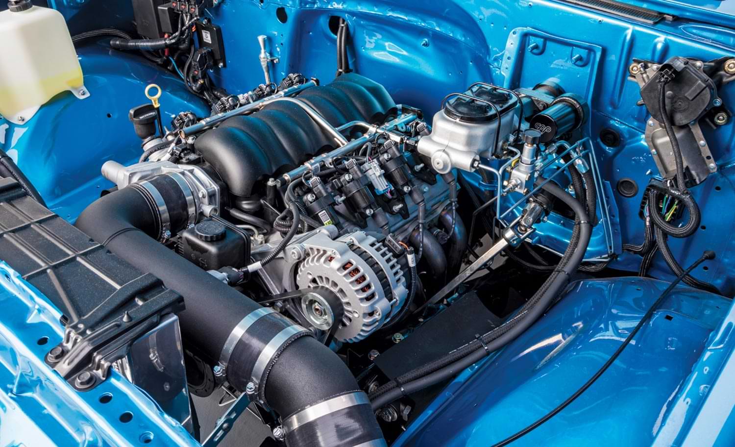 a mass airflow metering system under the hood of a blue car