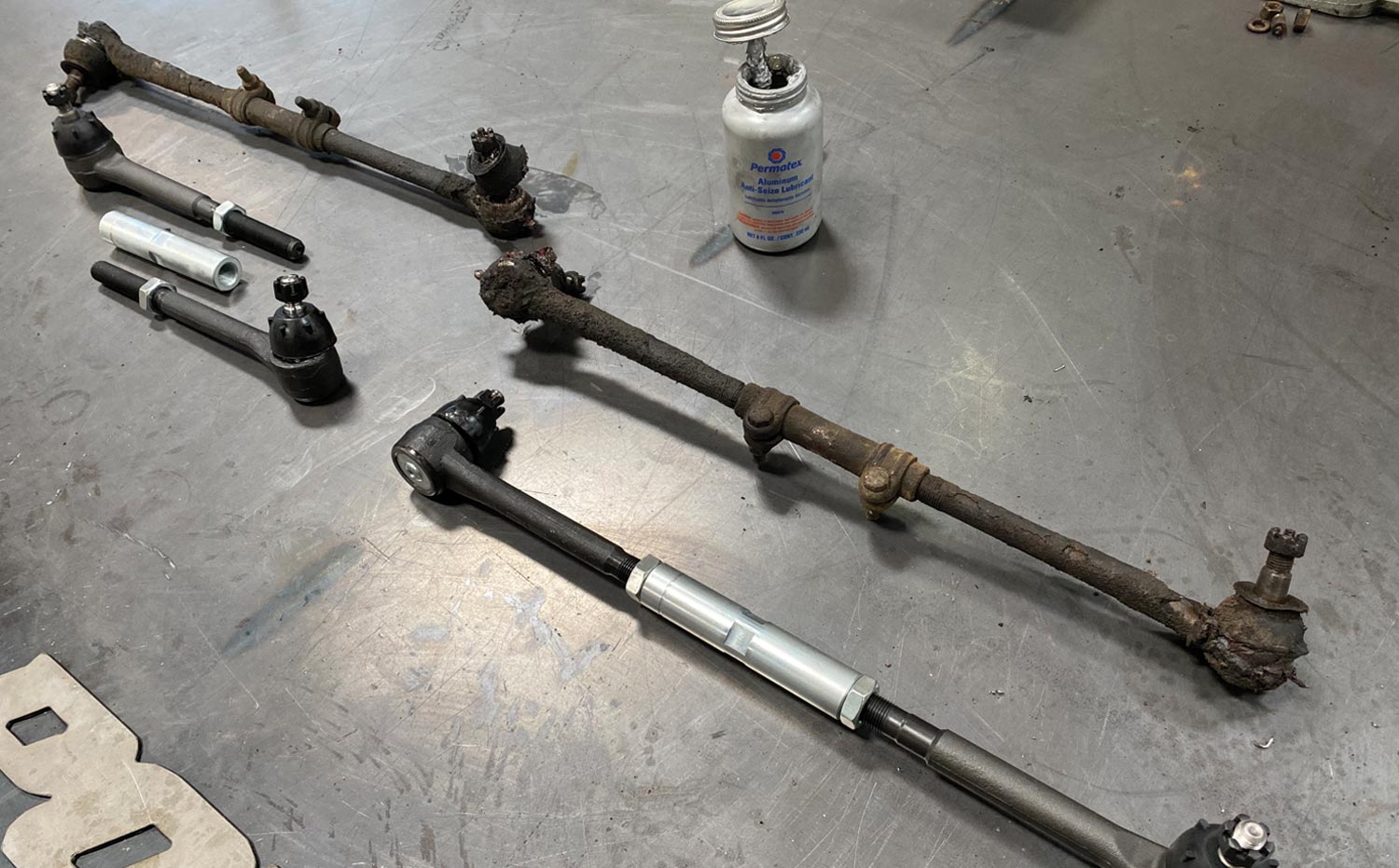 the new and original tie-rod ends sit side by side on a table top
