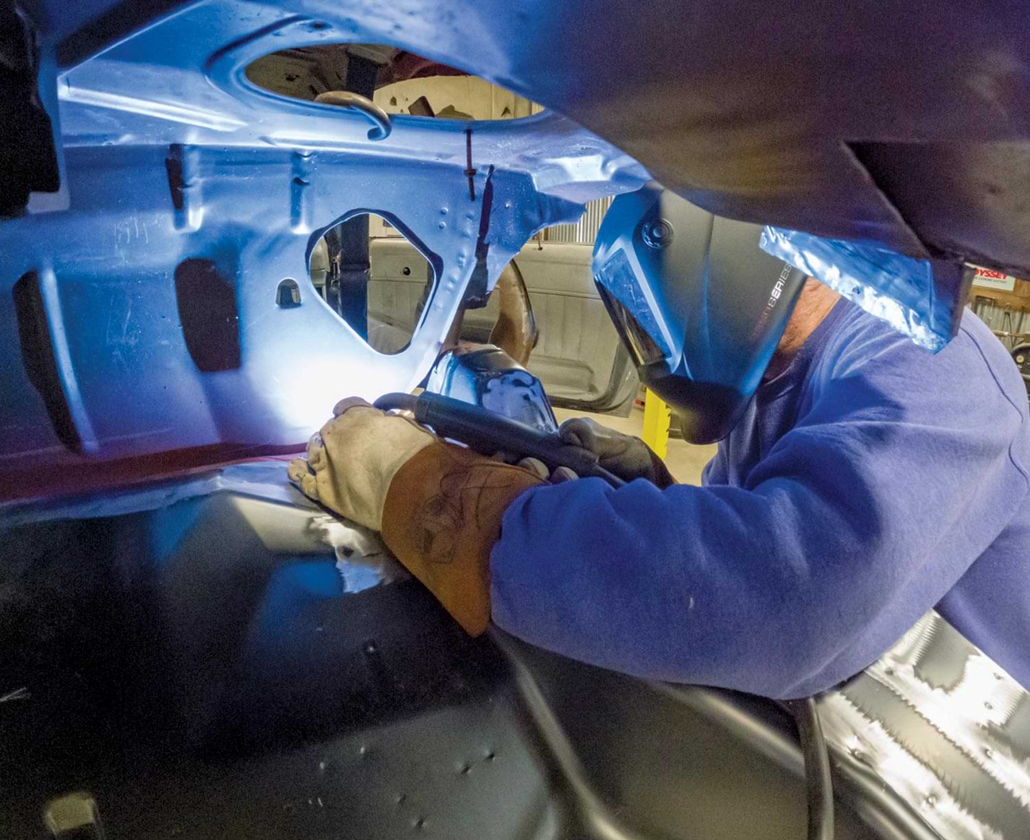 mechanic plug welds the harder-to-reach areas with his MIG torch