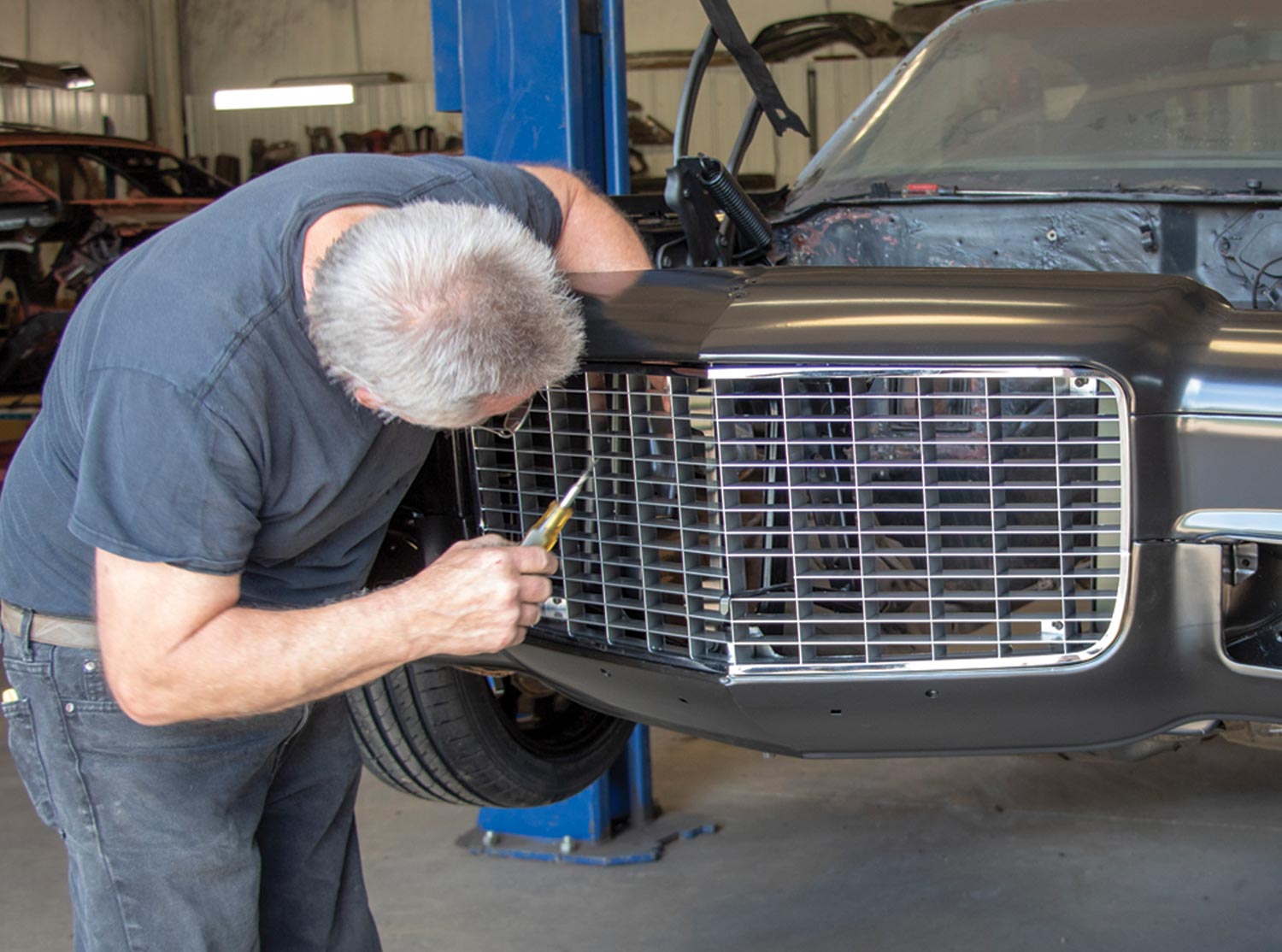mechanic installs the grille
