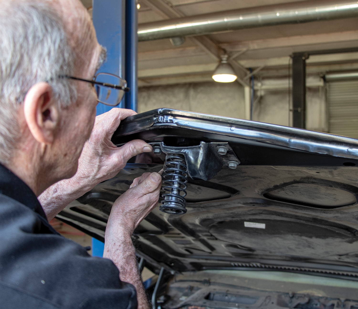 mechanic installs the new hood safety latch