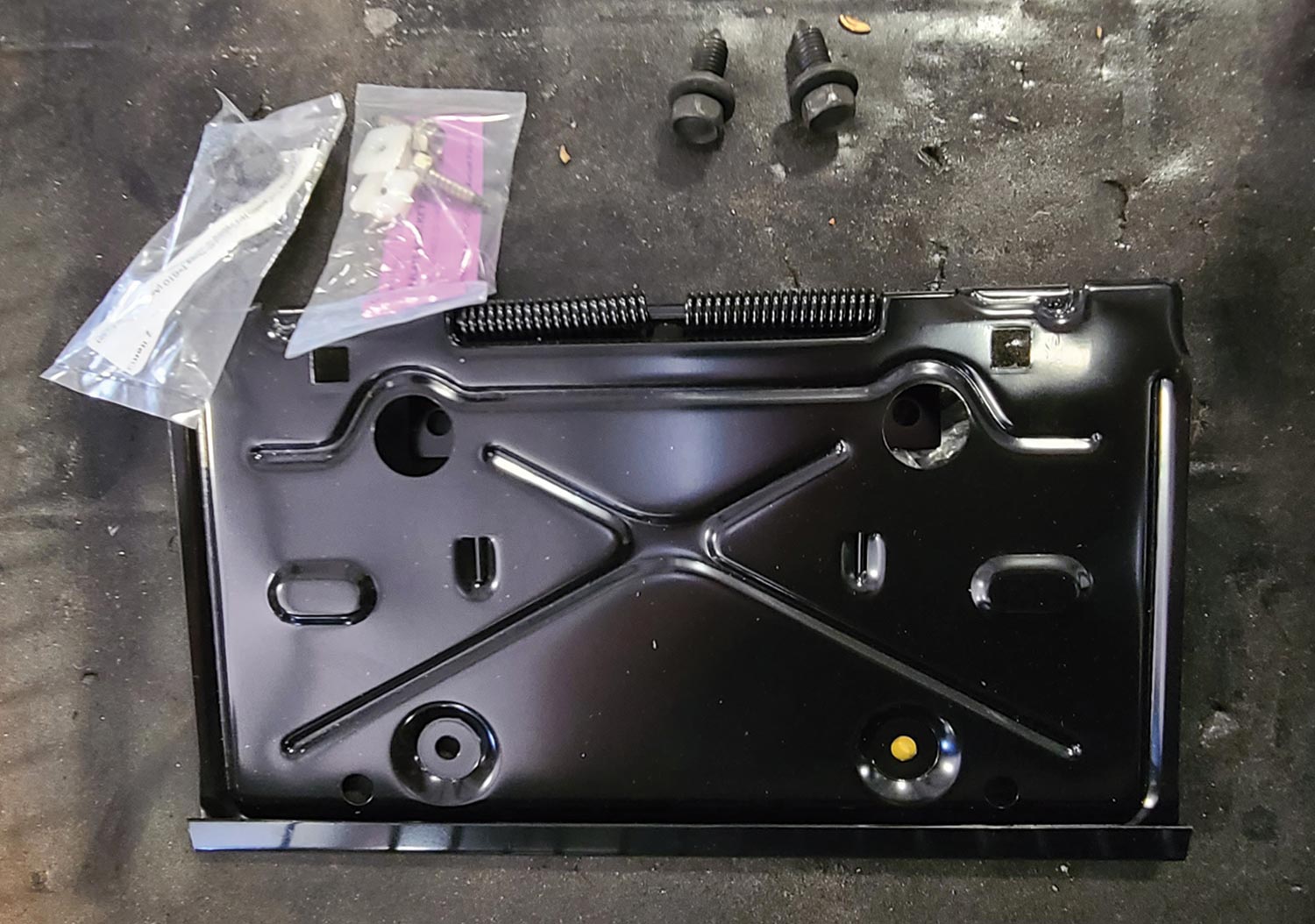 view of an all-new flip-down tag bracket and hardware before installation