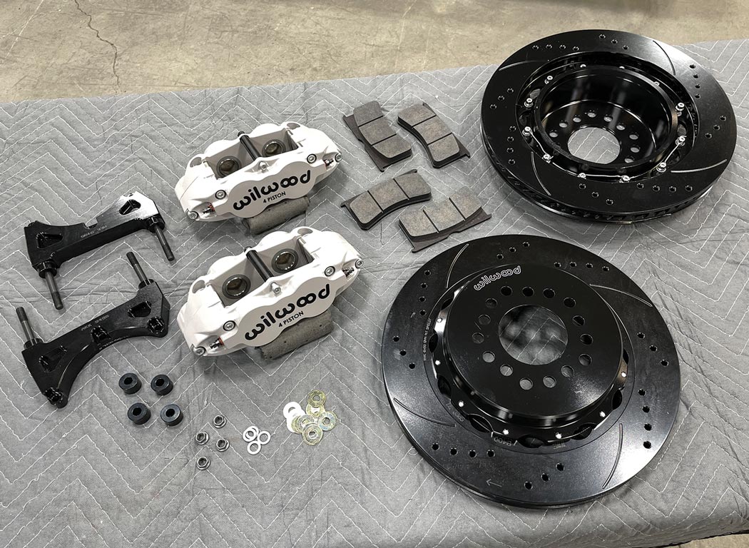 parts from the Wilwood Disc Brakes Forged Narrow Superlite 4R Big Brake Rear Parking Brake kit sit on a work surface organized for install