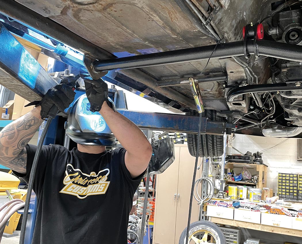 the mechanic welds the brace in place to the bottom of the subframe connectors