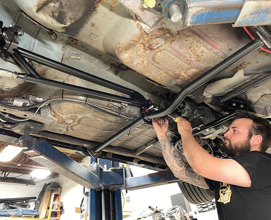 mechanic installs the BMR Trak Pak torque arm to the rear axle and brace using the provided pivot points