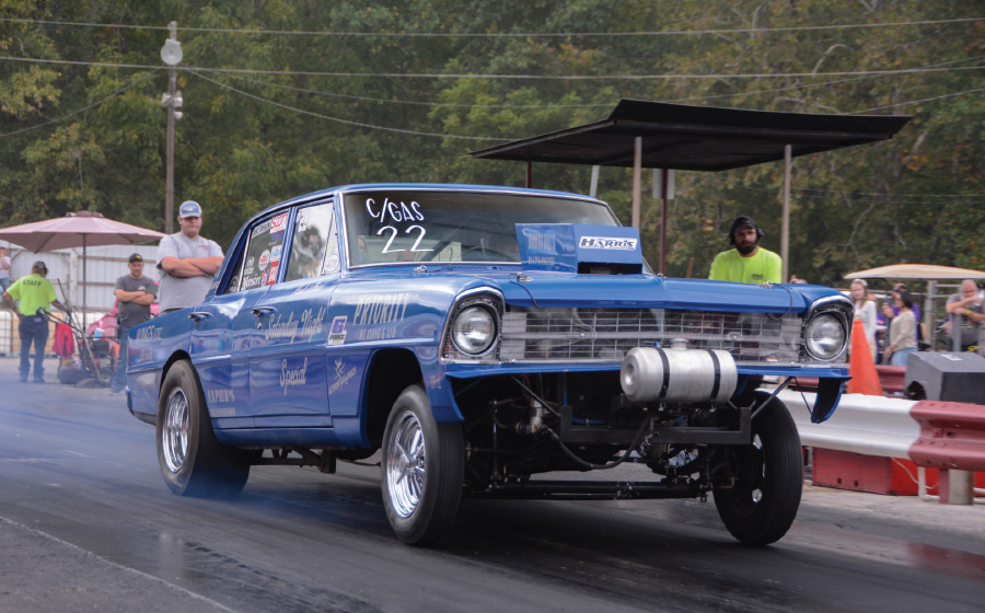 blue hot rod taking off with smoke behind tires