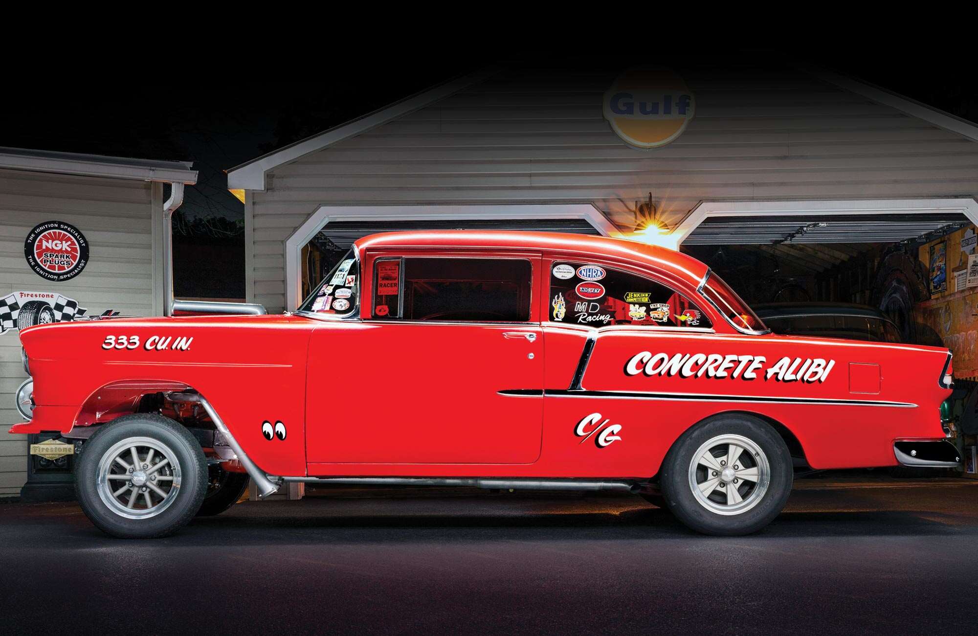 driver's side profile of the '55 Chevy gasser, with various vintage stickers on the windows and graphics on the body including the wording "Concrete Alibi"