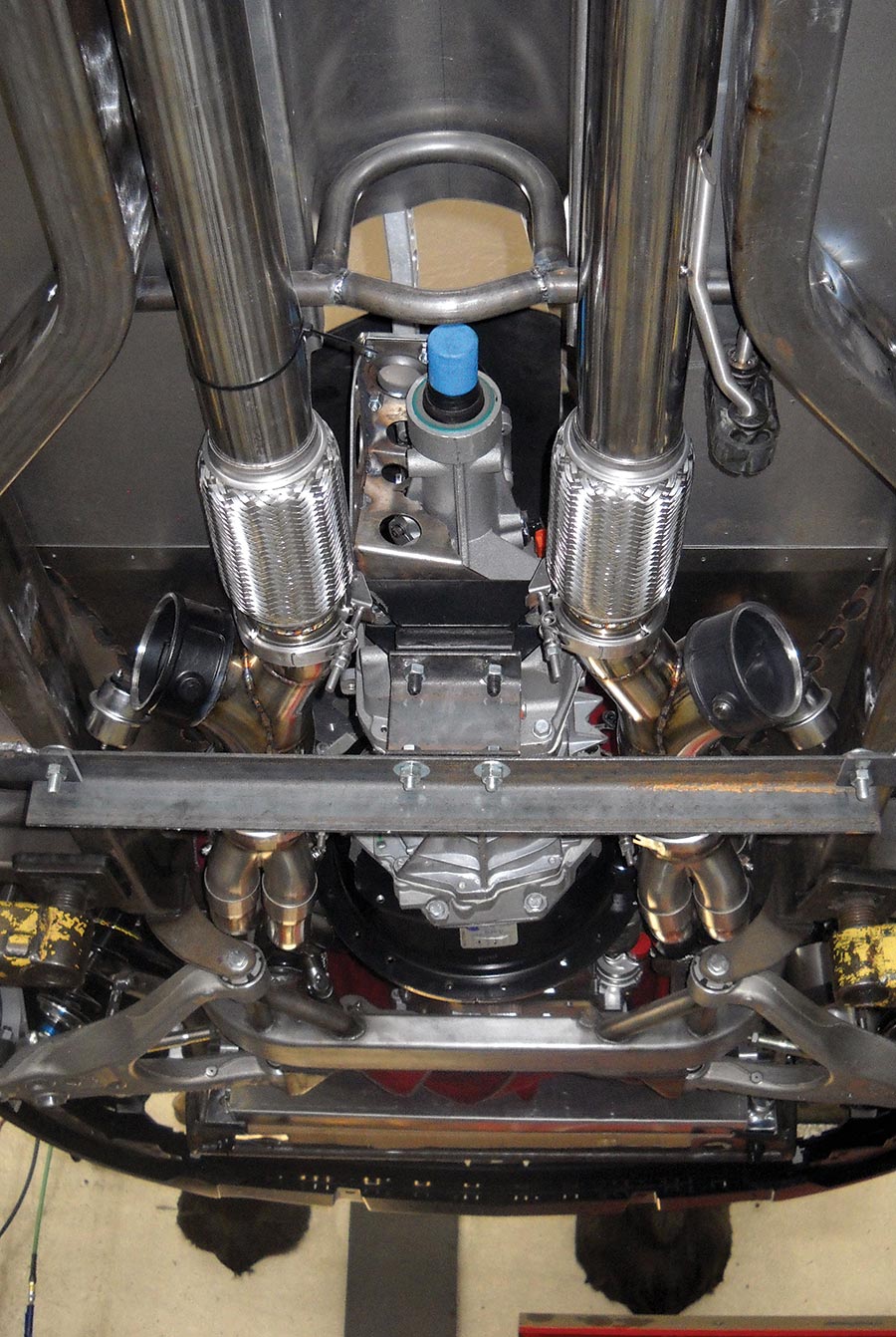 A TREMEC six-speed is shown mocked in place with a temporary crossover, while the exhaust system is fabricated.
