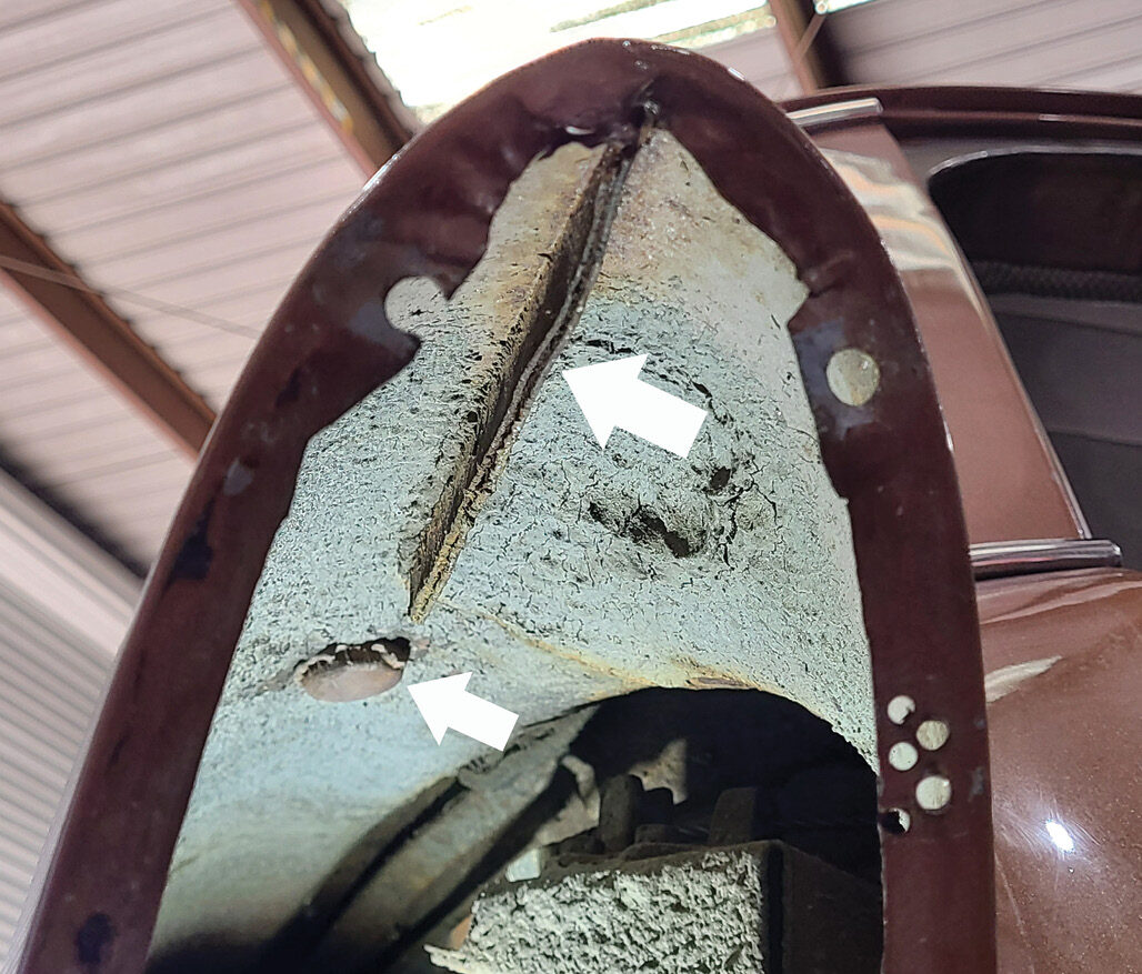 This Handyman wagon body has this factory-welded seam (large arrow) that interferes with the gas filler plate that will be installed next. The smaller arrow points to the upside-down bottle cap that was inserted into the rear antenna hole (on both quarters) by a previous bodyman and then covered with body filler.