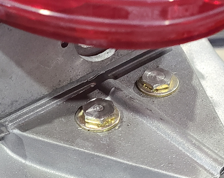 These two mounting screws for the housing are critically important because the slightest adjustment in them determines how well the housing will fit against into the taillight opening. Washers will determine height adjustments.
