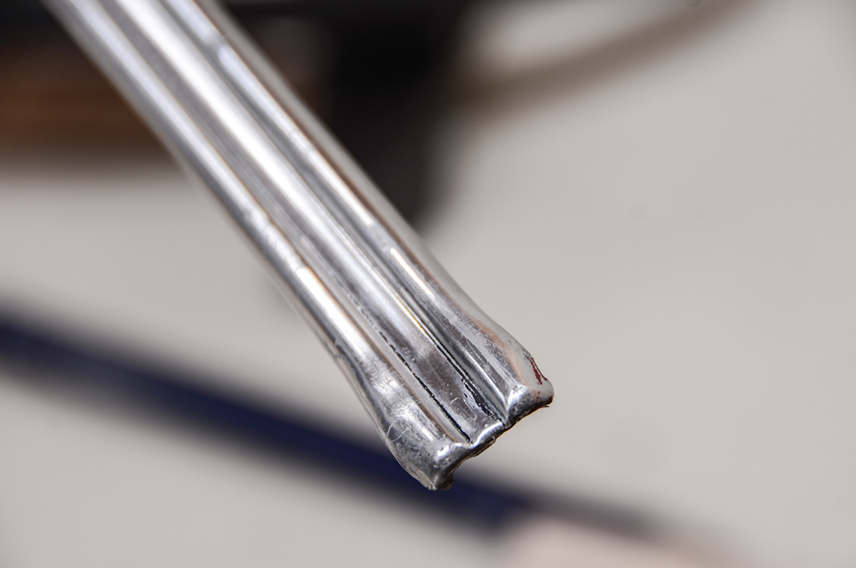 It’s very common for side moldings to get smashed on the ends. We used a vise to carefully squeeze the end back into shape and then massage it back into the proper shape. With any type of damage that stretches the aluminum this badly, we want our hammering to result in the damaged metal being slightly “up” so it can be filed down.