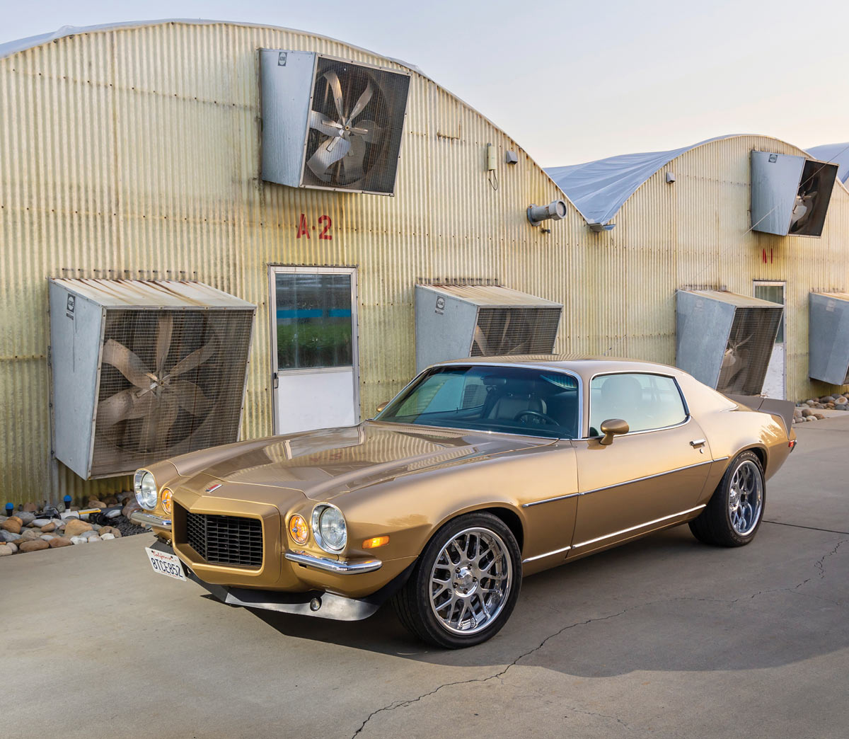 Front 3/4 view of Camaro in front of rusty hangars