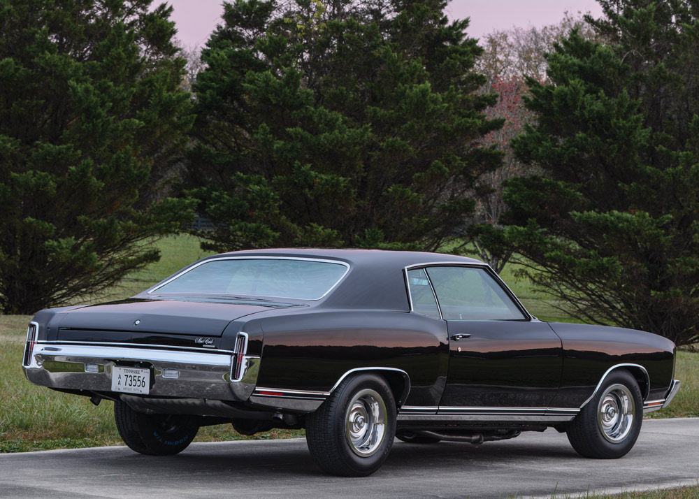 rear view of '71 Monte Carlo with green trees and grass behind