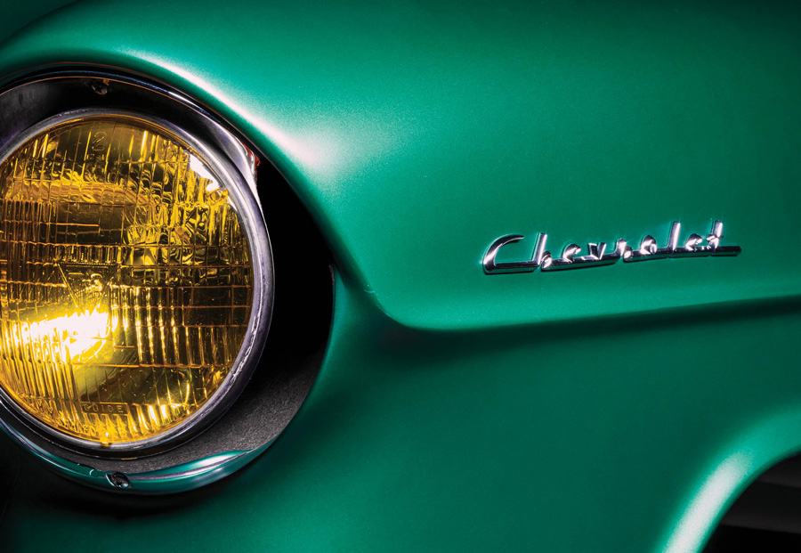 yellow headlight and Chevrolet emblem on an emerald green '55 Chevy