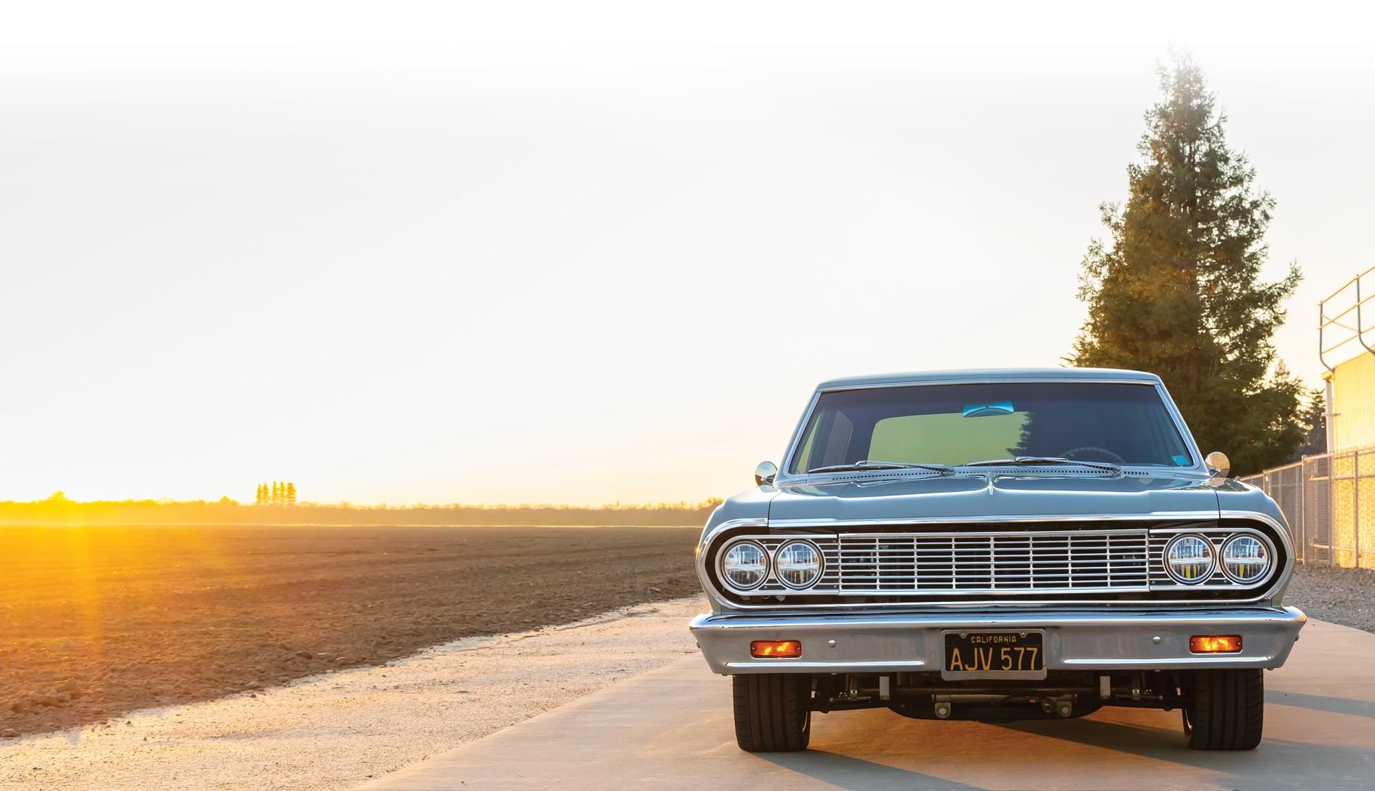 '64 chevelle wagon with country side behind and sunset in the distance