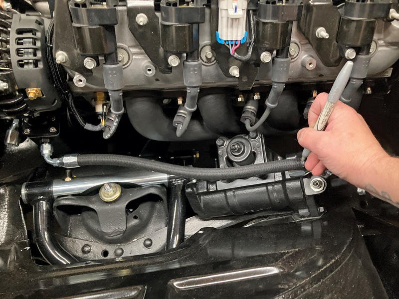 Next, it’s time to measure and cut the other end of the hose. A silver Sharpie marker is used in addition to a fully assembled socket assembly, installed on the steering box for reference.