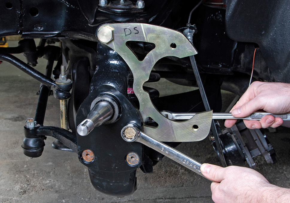 No guesswork here, no spacers necessary. The top of the bracket will bolt quite obviously to the front of the spindle, while the lower portion is mounted inboard with a bolt and nut on the backside.