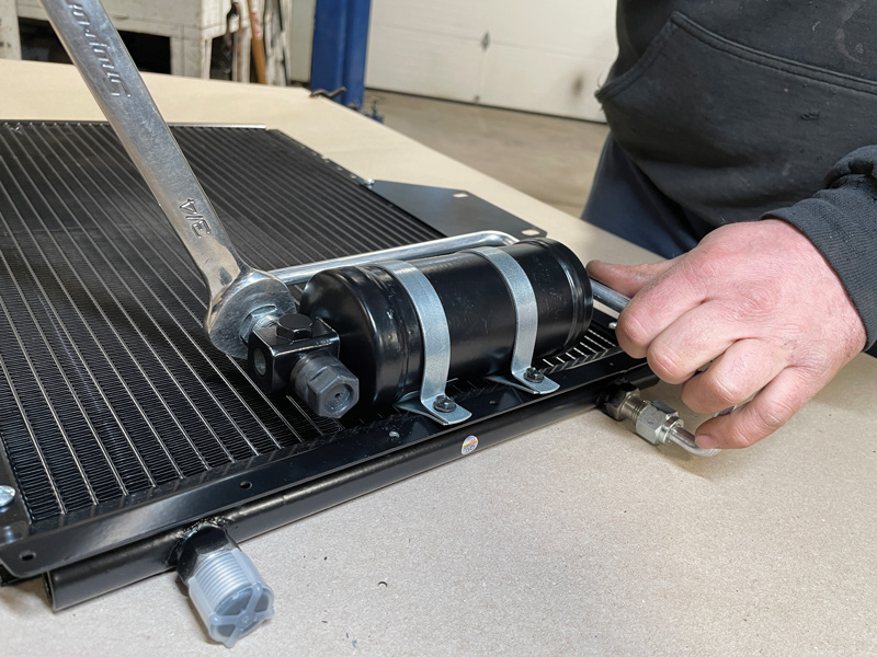 Using a ¾-inch wrench, carefully secure the hard line to the drier and condenser.