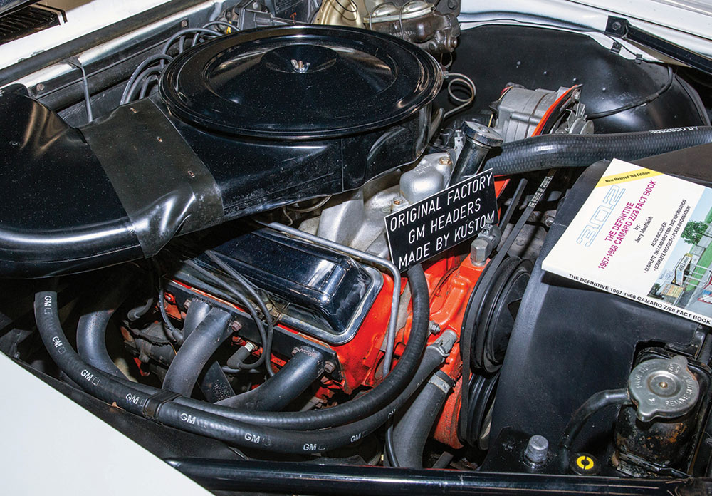 Closeup of 302 with sign reading "original factory GM headers made by Kustom"