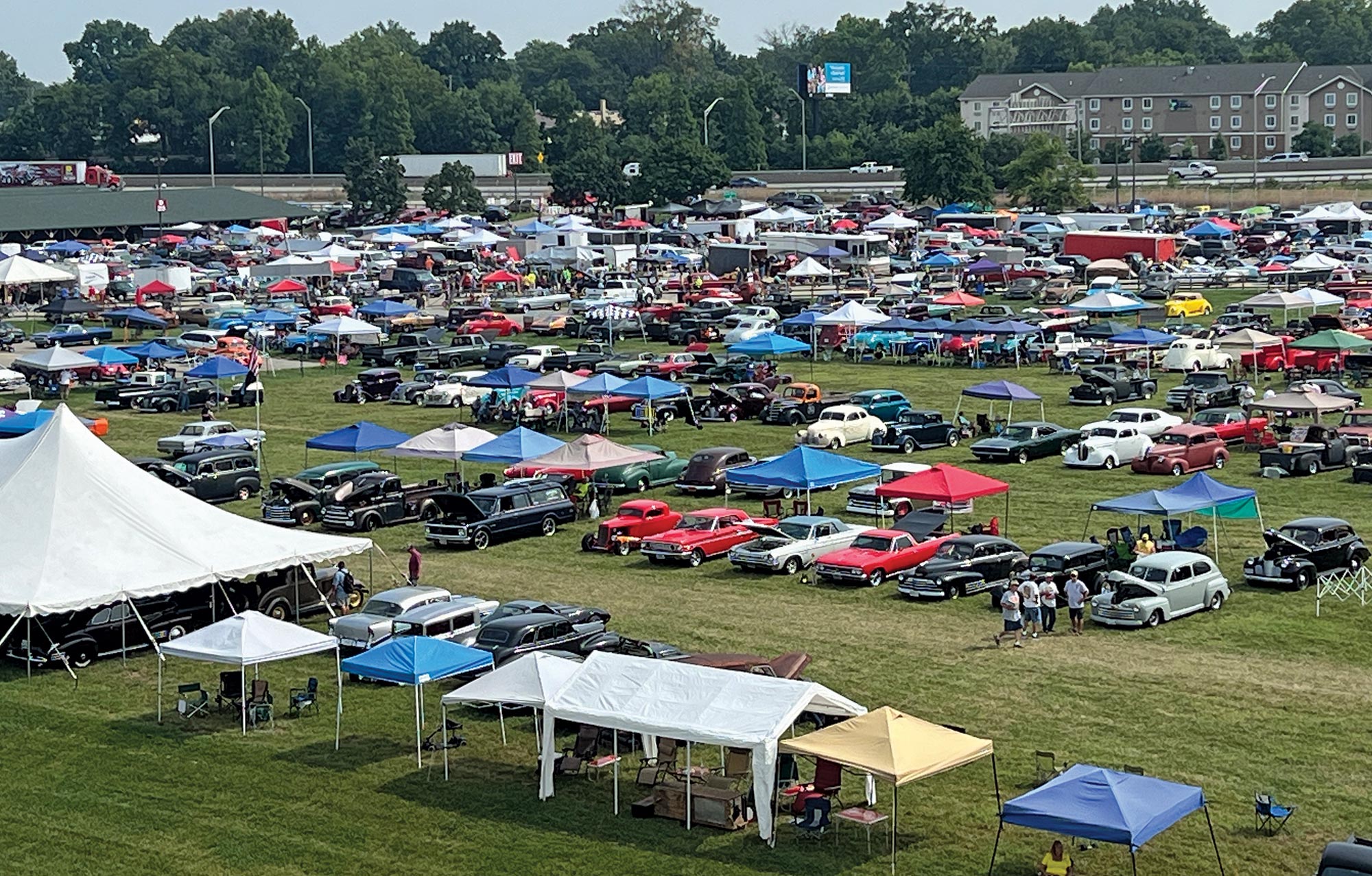 Large grass field area in Louisville, Kentucky with numerous cars, tents, and people gathered together for the 54th annual NSRA Street Rod Nationals