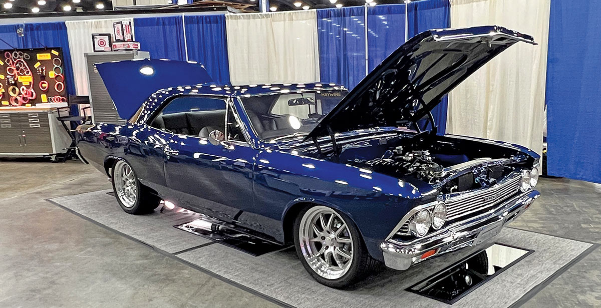 Close-up photograph perspective of a shiny dark blue Chevy vintage car on display with its hood opened up at the 54th annual NSRA Street Rod Nationals