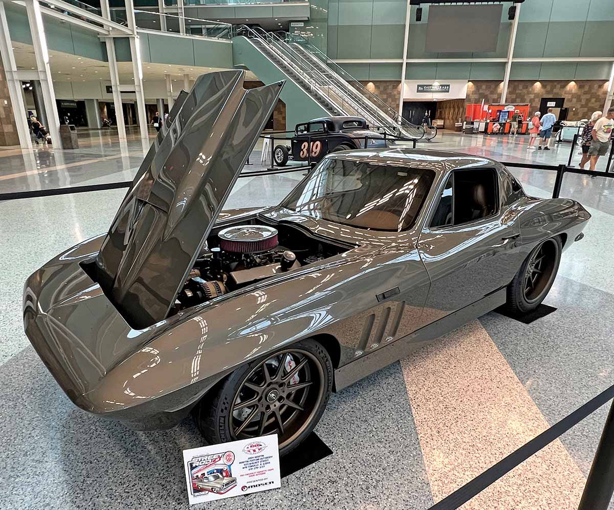 Close-up photograph perspective of a shiny bronze vintage Chevy car on display with its hood opened up at the 54th annual NSRA Street Rod Nationals