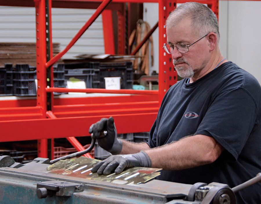 A metal brake is used to fold the edges of the brass for a strong, finished edge that will fit tightly in the header panel.