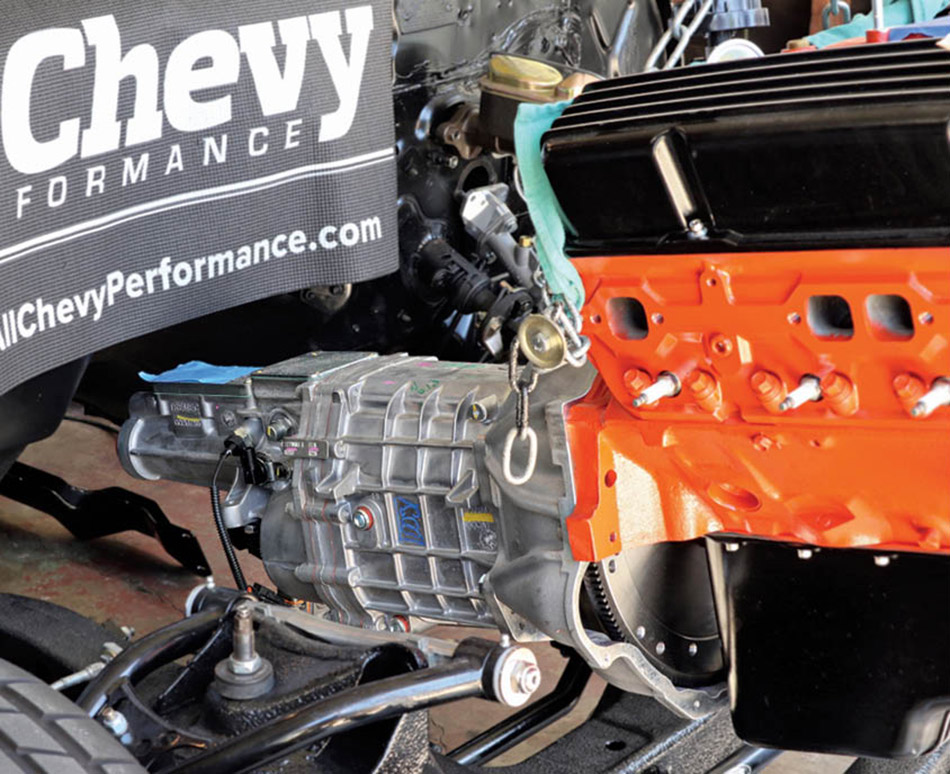 Next we loaded our new drivetrain into the Nova to see how much more material needed to be removed. We left a fender cover against the firewall to protect from scratches and used a floor jack under the end of the five-speed to control the angle.