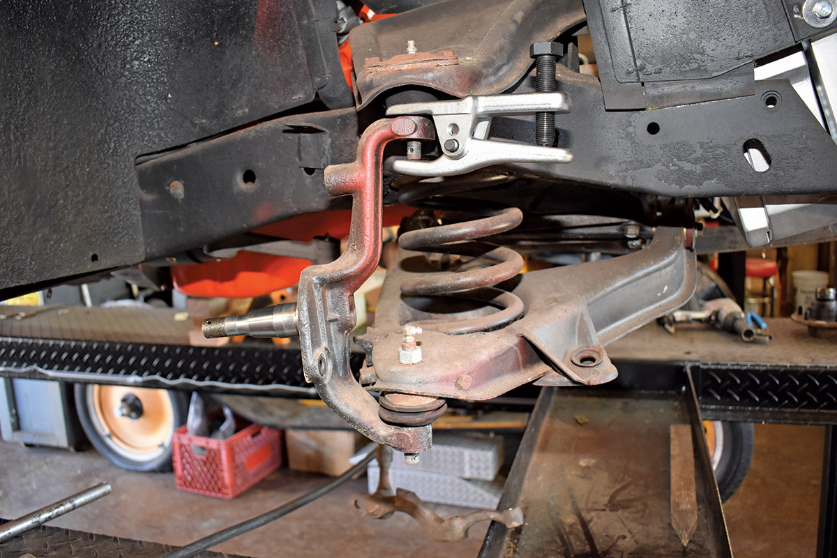 A Chevy control arm being worked on