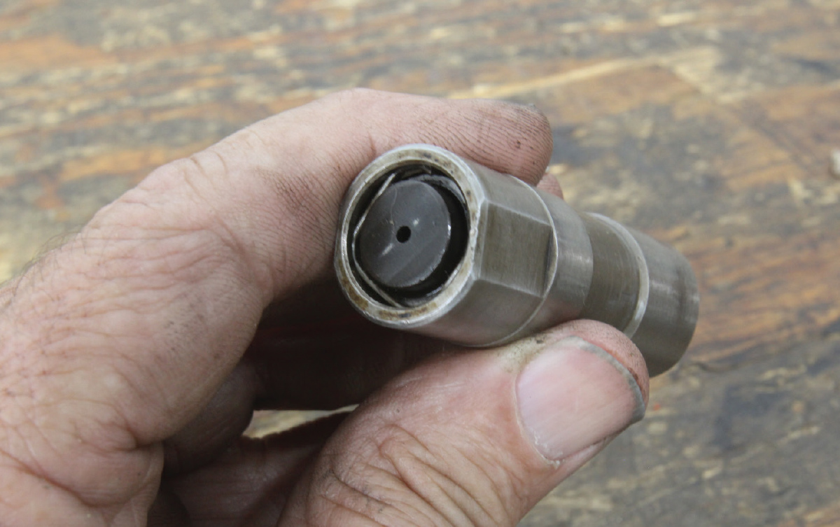 For degreeing cams, we prefer to use an old roller lifter as a lobe follower. We remove the piston and flip the pushrod seat over and use the oil feed hole as a convenient point to locate the dial indicator plunger.