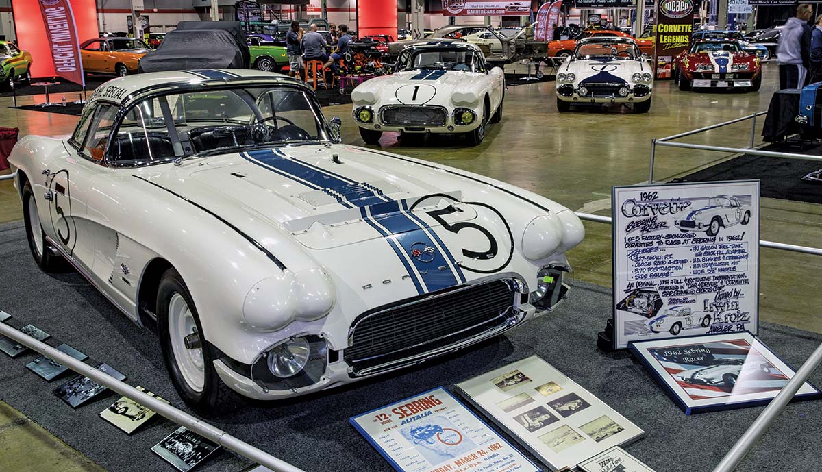 Close-up photograph perspective of a vintage No. 5 '62 Bardahl Special Corvette muscle car in white/black/blue in a display area of a showroom floor