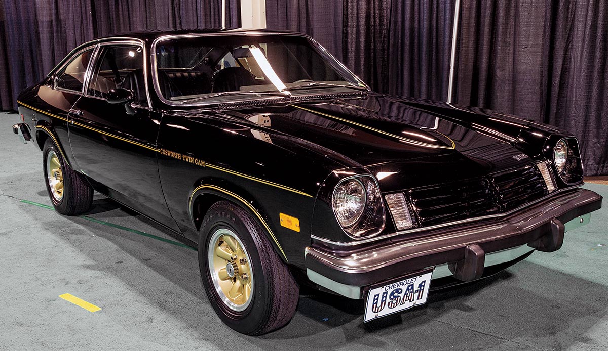 Close-up photograph perspective of a black/yellow vintage Cosworth Vega car in a display area of a showroom floor