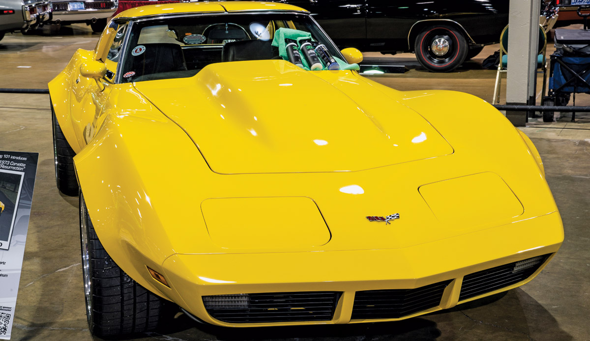 Close-up photograph perspective of a yellow vintage Corvette car in a display area of a showroom floor