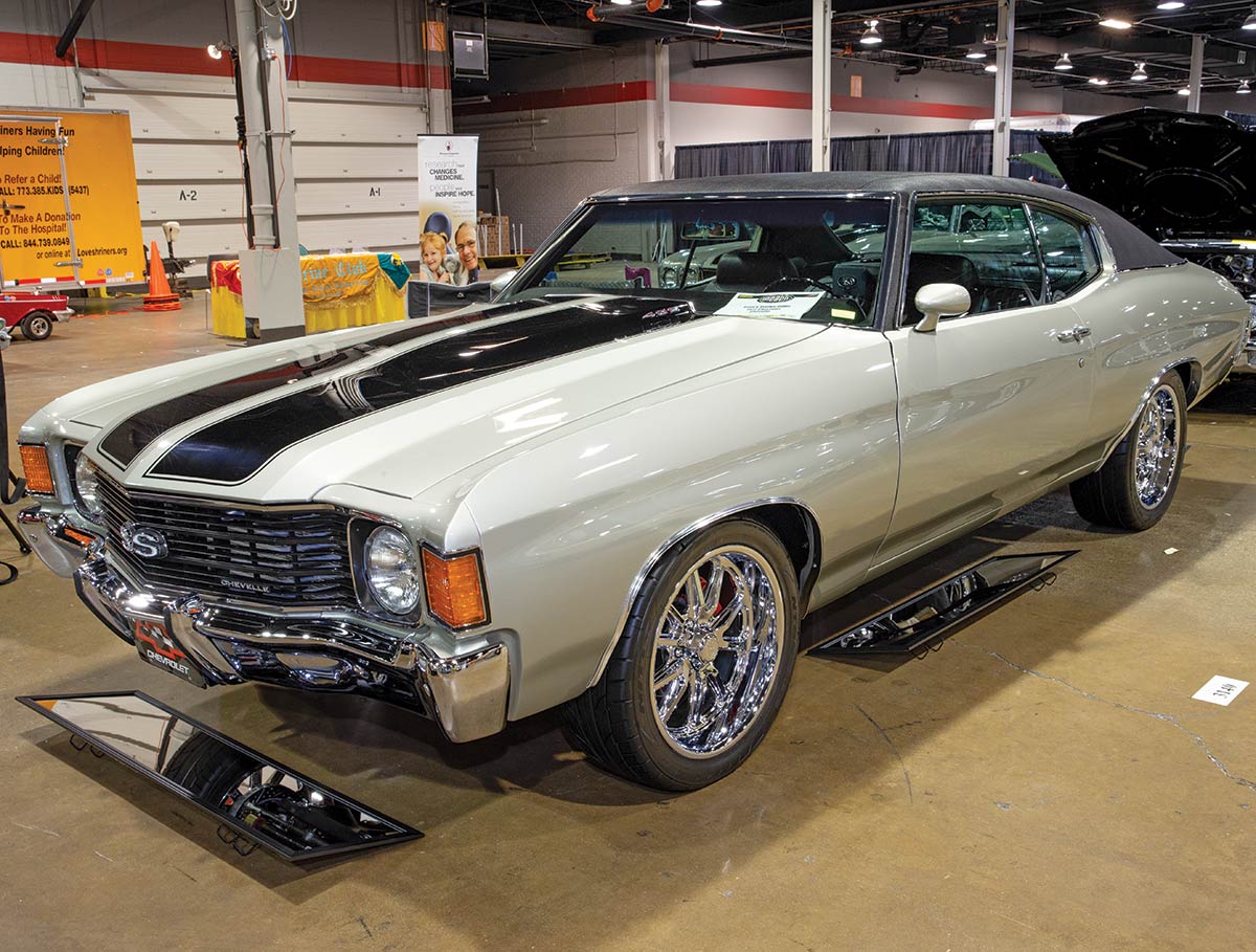 Close-up photograph perspective of a vintage light faded grey/black ’72 Chevelle car in a display area of a showroom floor