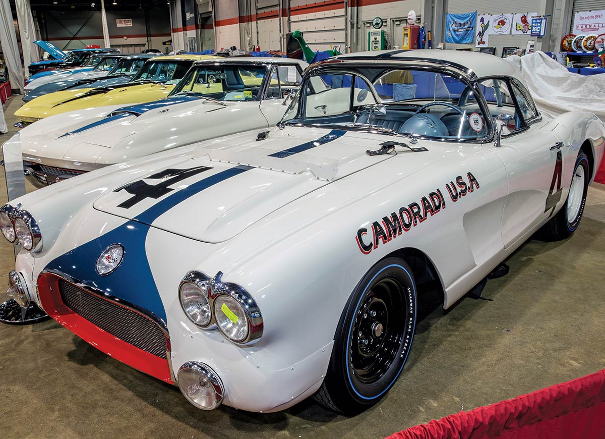 Close-up photograph perspective of a vintage white/blue/red custom-themed ’60 Corvette car in a display area of a showroom floor